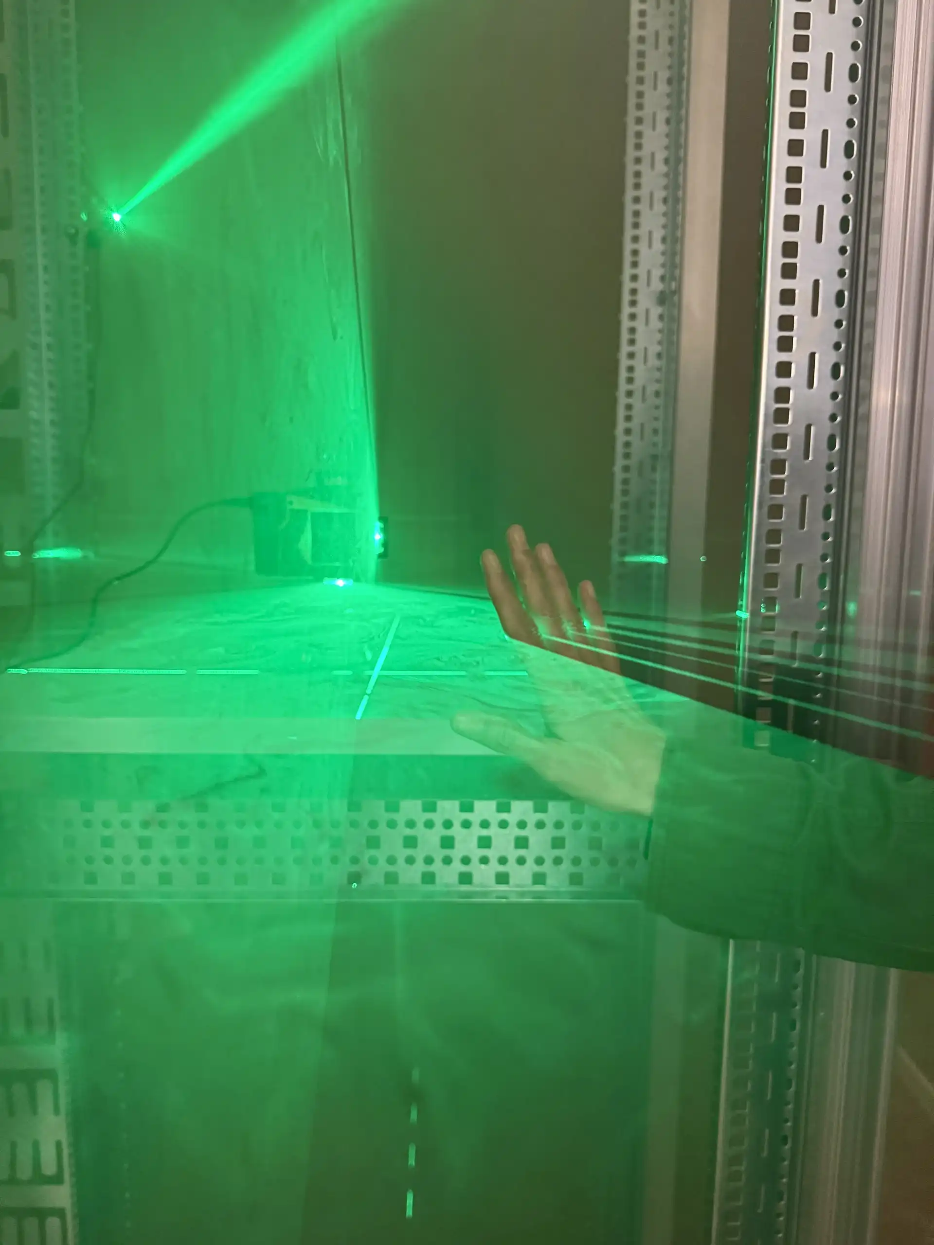 Grüne Laser und eine Hand die Rauch trennt