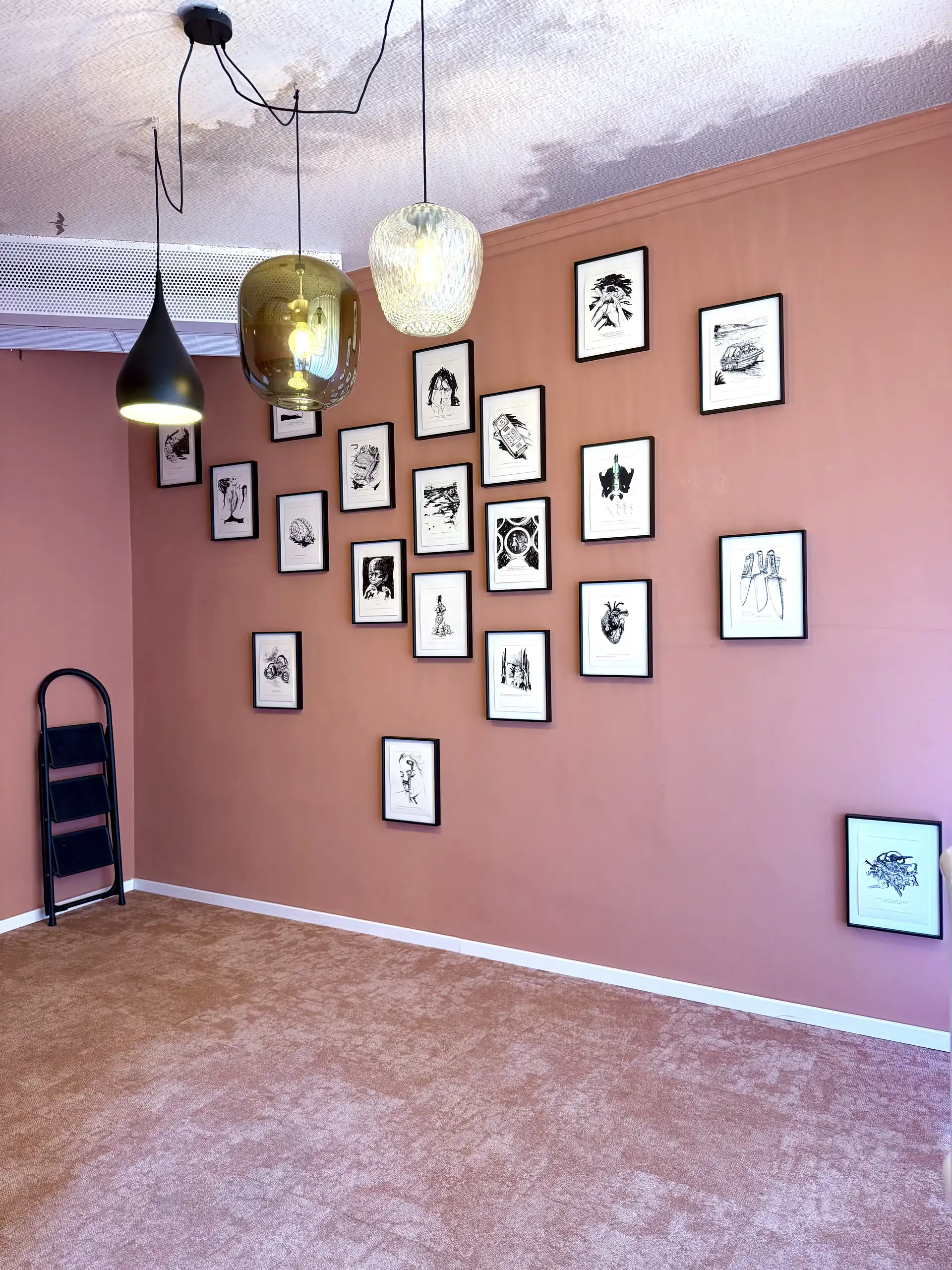 Zeichnungen in Bilderrahmen an einer Ausstellungswand