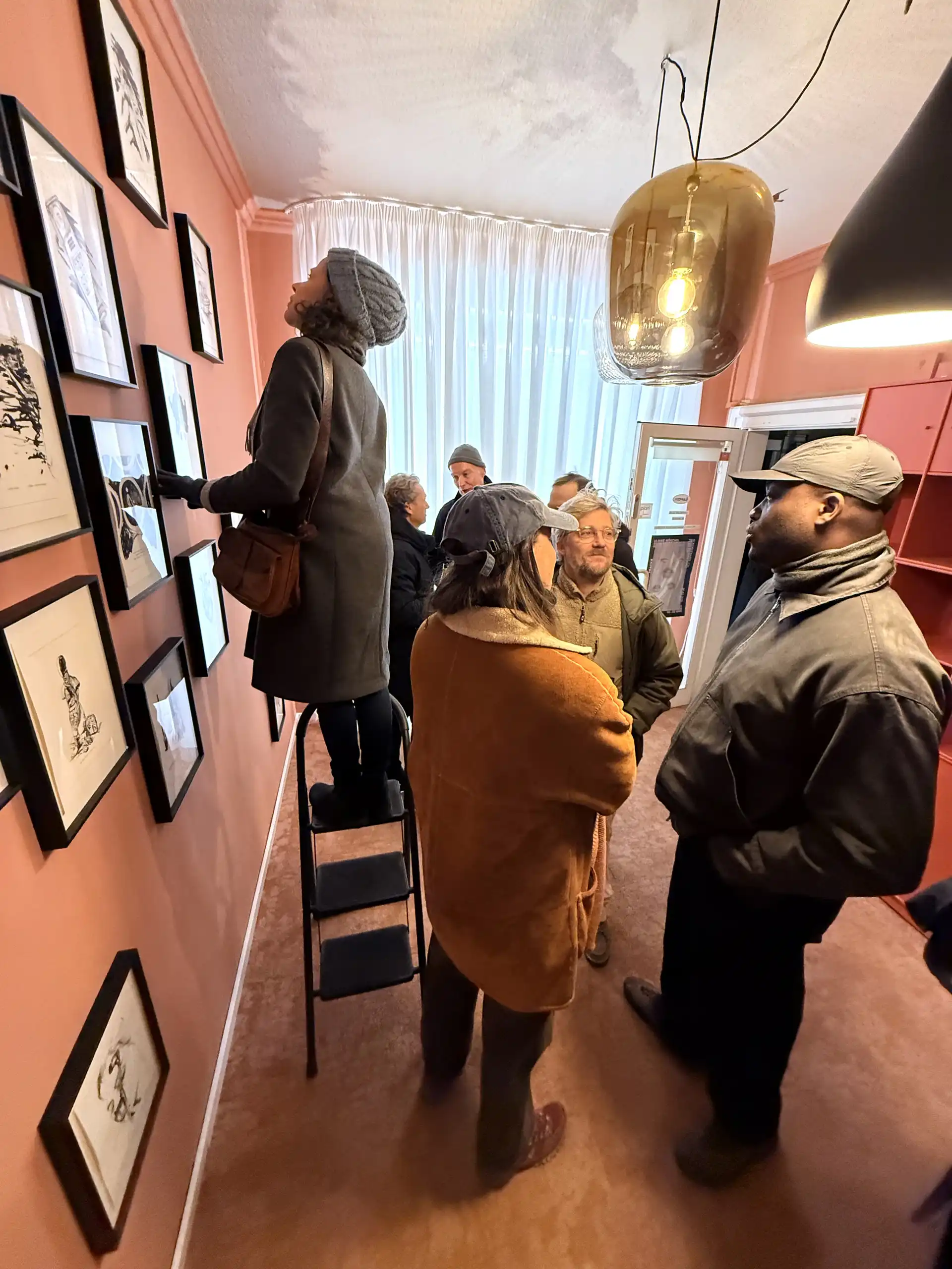 Personen, die sich Bilder in einer Ausstellung anschauen