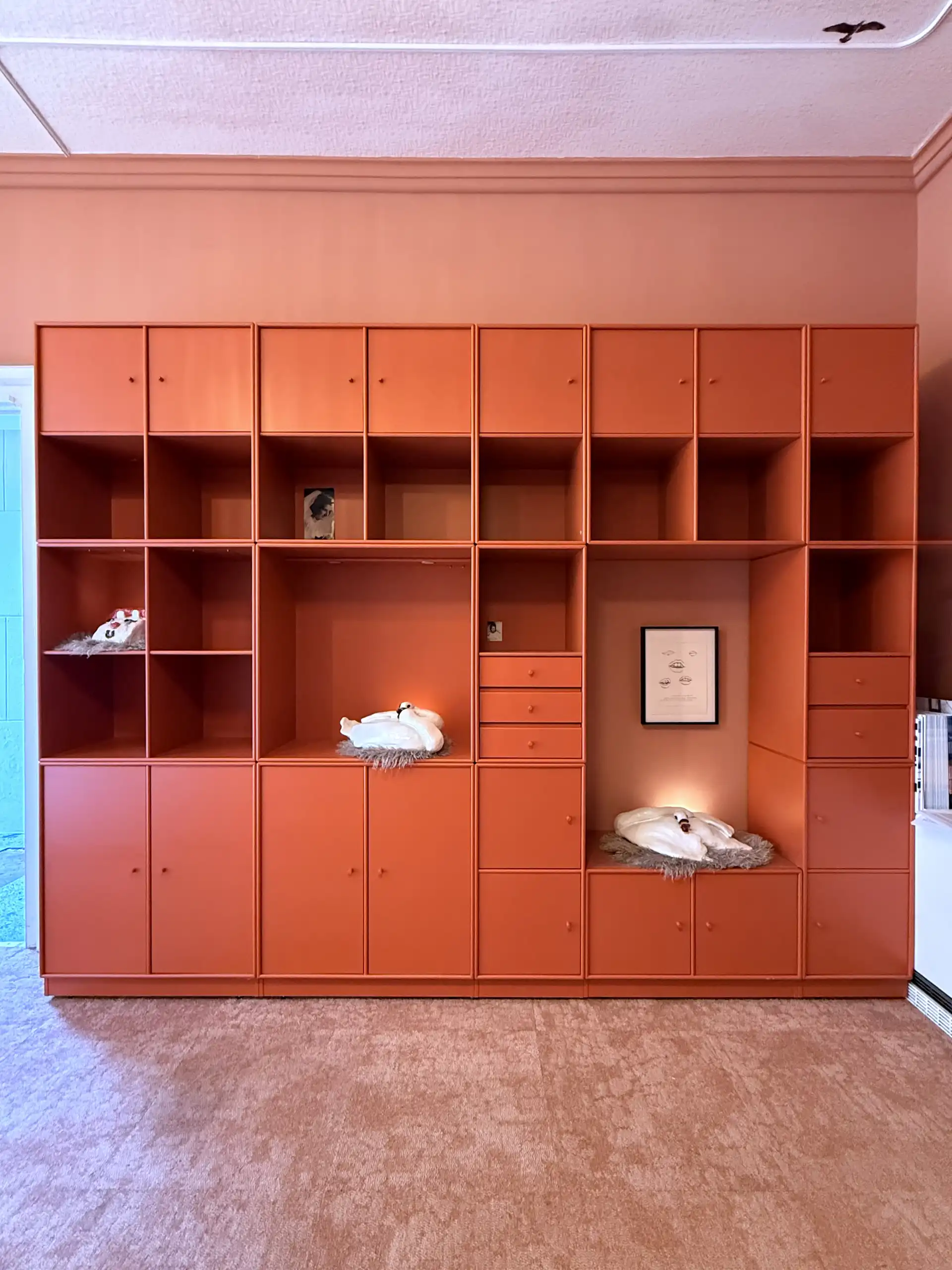 Eine große Schrankwand mit ausgestellten Kunstwerken