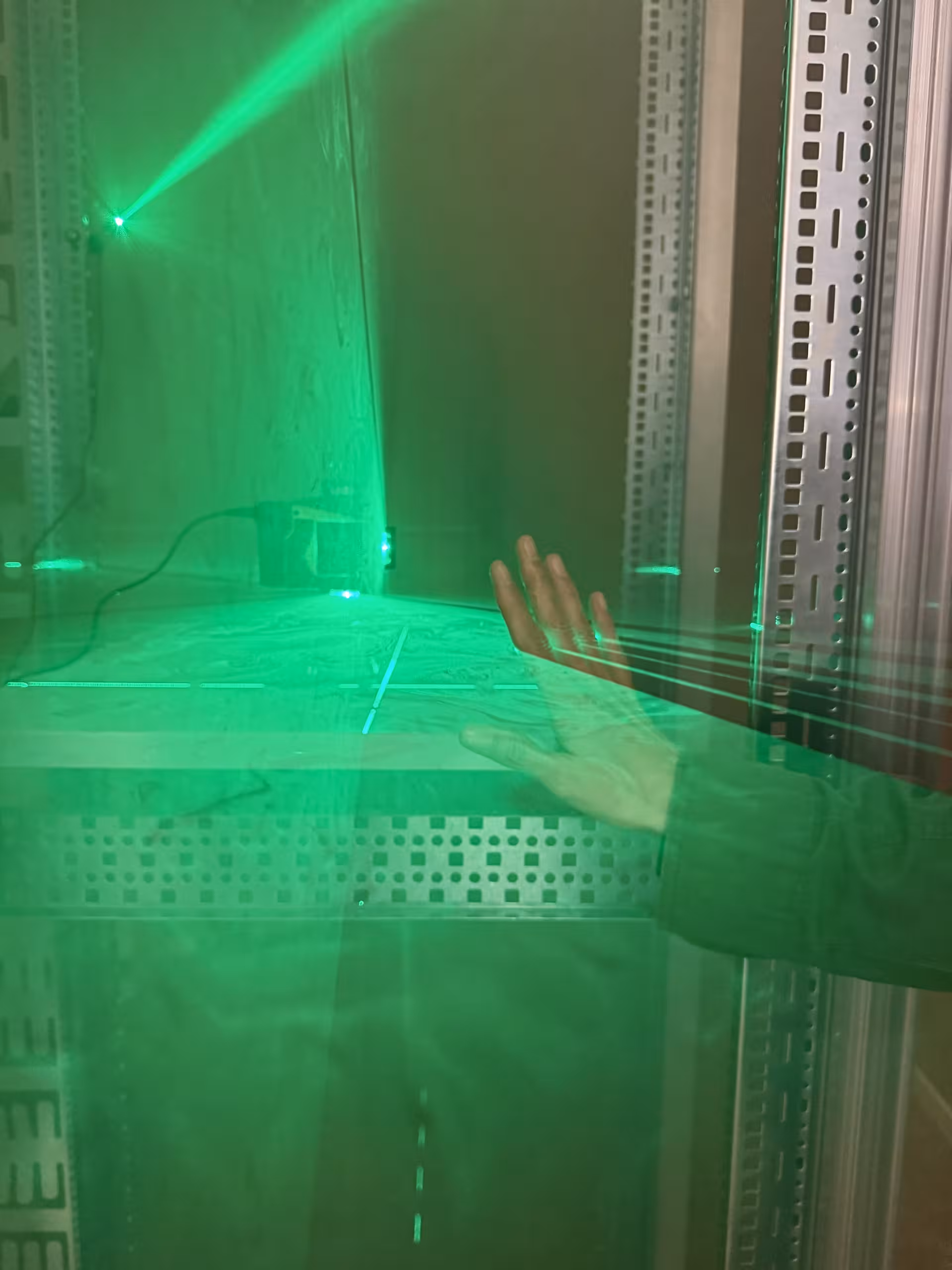 Grüne Laser und eine Hand die Rauch trennt