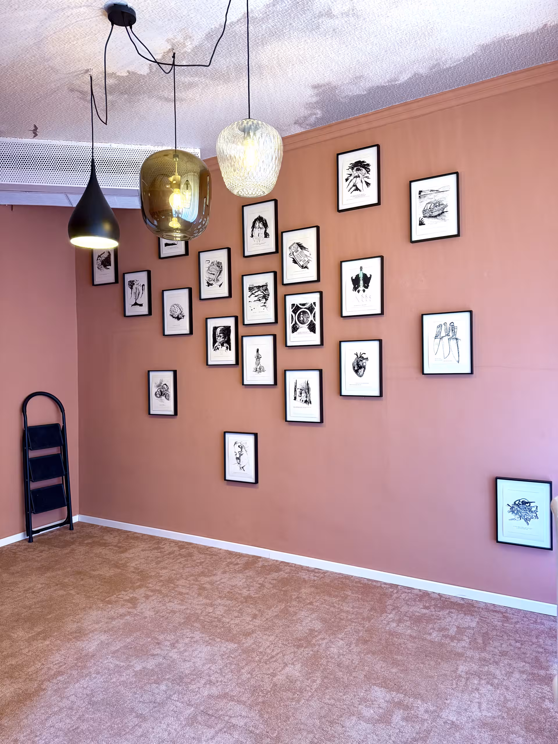 Zeichnungen in Bilderrahmen an einer Ausstellungswand