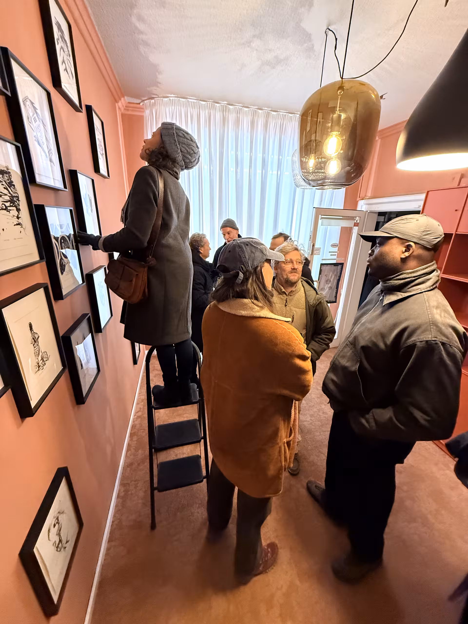 Personen, die sich Bilder in einer Ausstellung anschauen