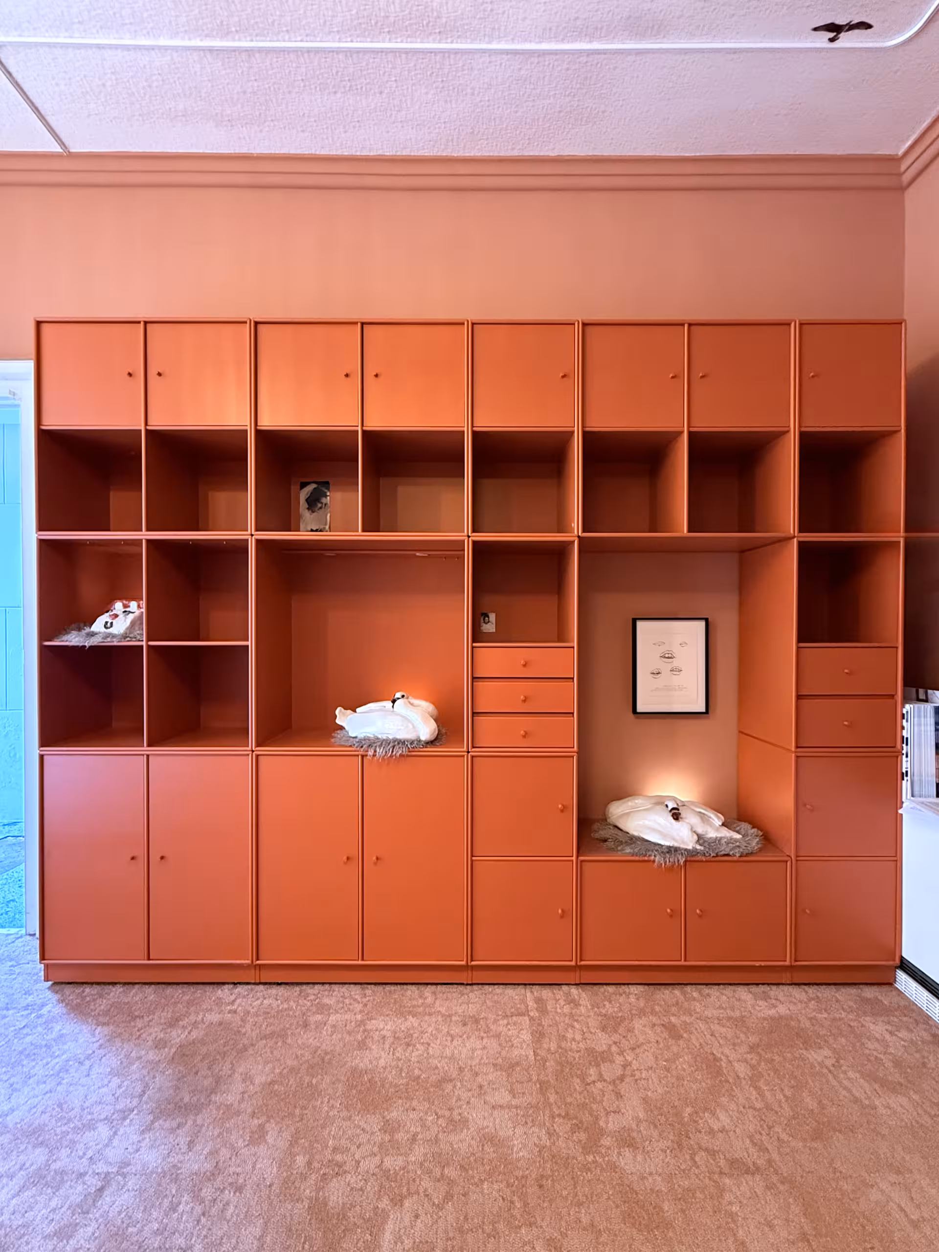 Eine große Schrankwand mit ausgestellten Kunstwerken